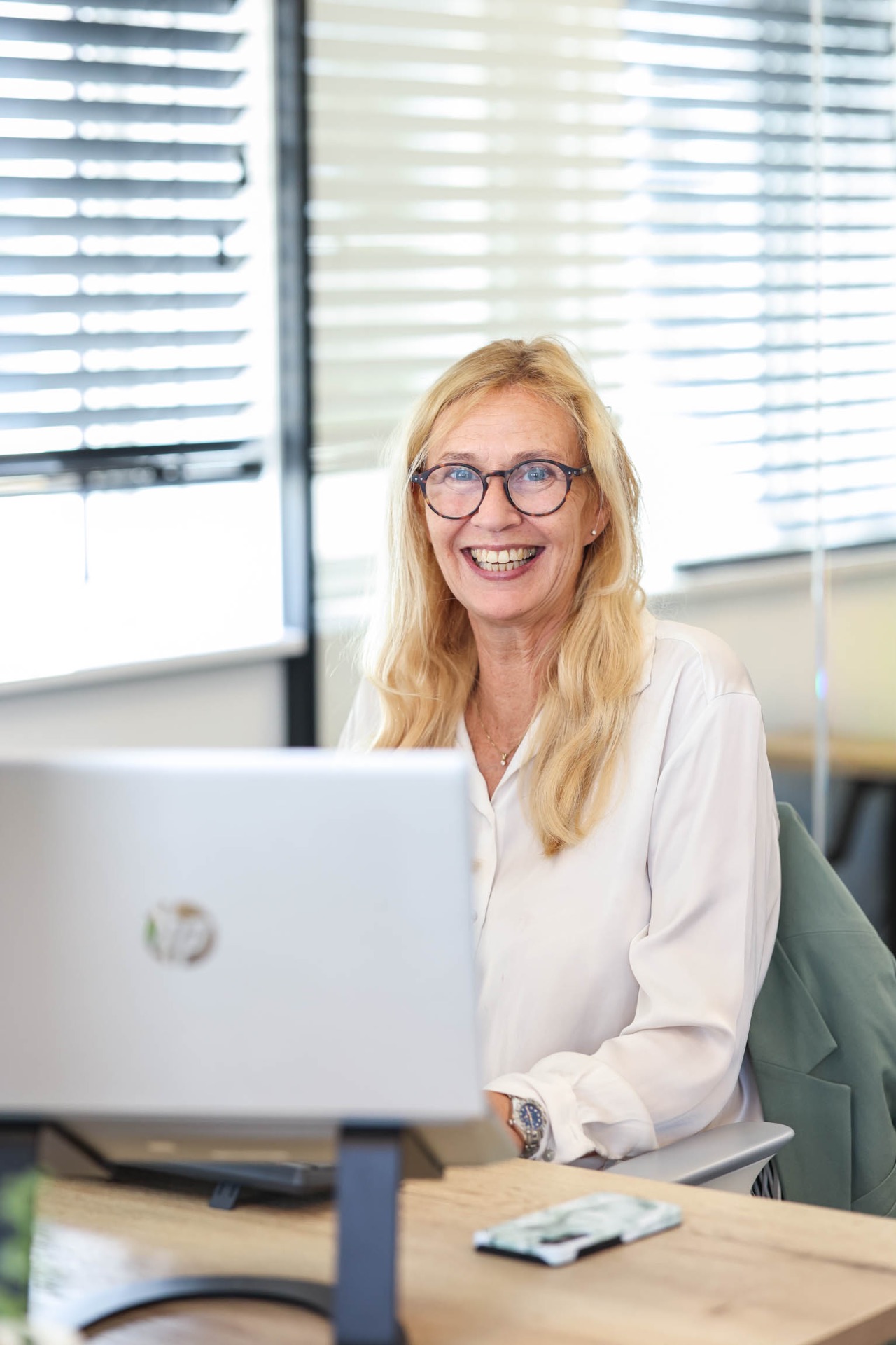 Bedrijfszorgadviseur achter haar laptop op kantoor bij Expert Care